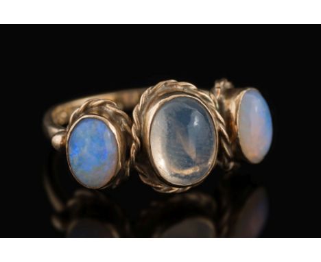 A 9ct yellow gold, opal and moonstone three stone ring: with central moonstone, 9mm long x 7mm wide, between smaller, oval op