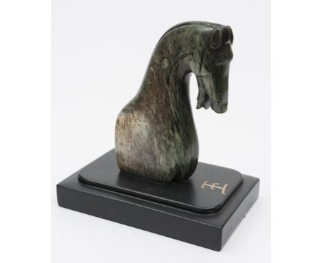 A Chinese jadeite carving of a horse's head: in Han Dynasty style, modelled with partial torso, it's head lowered and mouth o