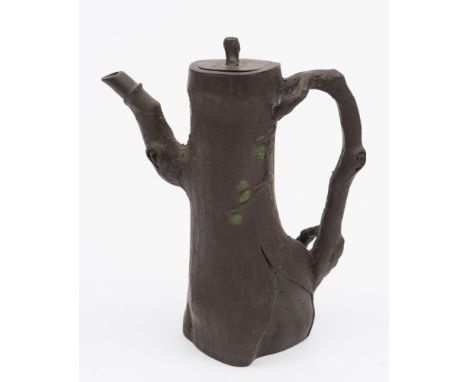 A Yixing teapot and cover: of dark brown colour modelled as the trunk of a fir tree, the handle and spout as gnarled branches