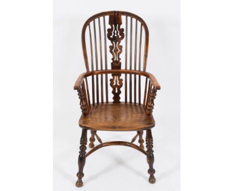 An early 19th Century elm and yew-wood stick back Windsor elbow chair:, the arched back with a pierced fret shaped central sp