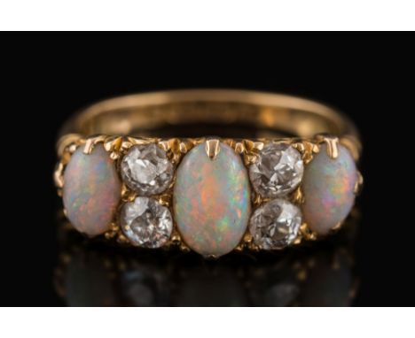 A late 19th century gold, opal and diamond seven-stone ring: with graduated oval opals separated by pairs of old brilliant-cu