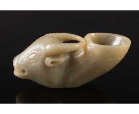 A Chinese carved jade ox's head rhyton: the animal with open mouth and carved diaper band to it's upturned neck, the stone of