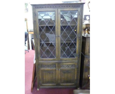 An Old Charm moulded oak and lead glazed bookcase, w.100cm; together with a linenfold moulded oak drinks cabinet, w.74.5cm; a