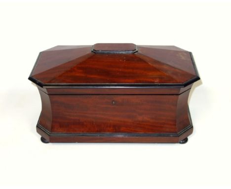 Victorian mahogany tea caddy of canted rectangular form with concave sides, the hinged cover enclosing a central well  flanke