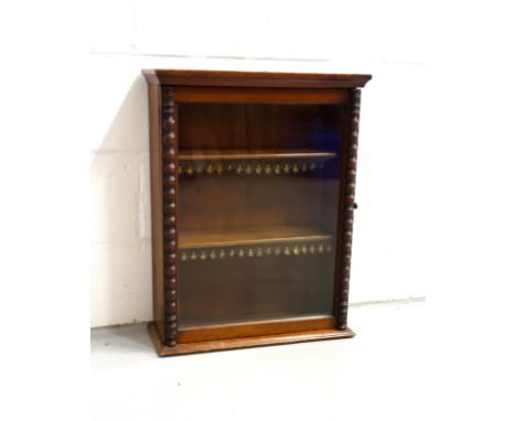 Edwardian mahogany cabinet with a glazed panelled door flanked by bobbin turned pilasters, on a plinth base, 66.4 x 51.1 x 20