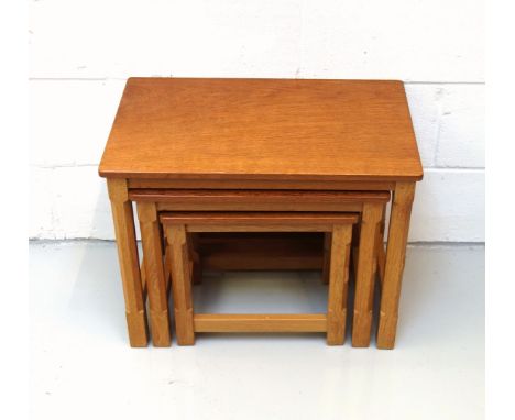 Mouseman, (Robert Thompson), oak nest of three graduating rectangular tables, each with an adzed top on chamfered square sect