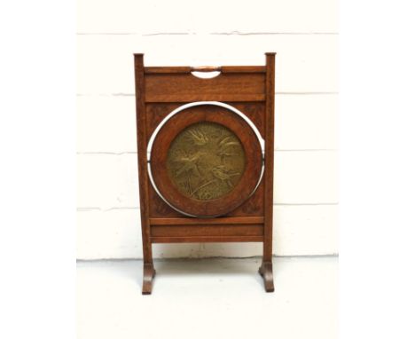 Unusual Aesthetic Movement oak metamorphic firescreen with central brass panel decorated in relief with four birds, the panel