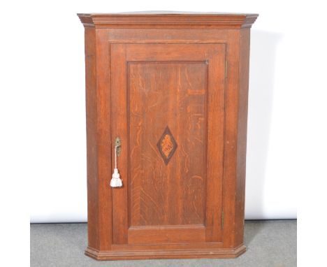 George III oak hanging corner cupboard, moulded cornice, panelled door with inlaid shell enclosing a shelf, width 78cm, depth