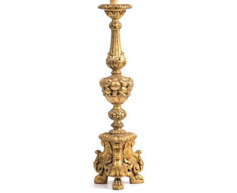 A GILT TABLE LAMP with moulded acanthus leaf and fruit decoration and within a triform base terminating in paw feet 76cm high