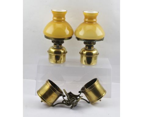 A PAIR OF EARLY 20TH CENTURY "ENGLISH MADE" BRASS WALL MOUNTED OIL LAMPS, each having detachable butterscotch colour opal gla