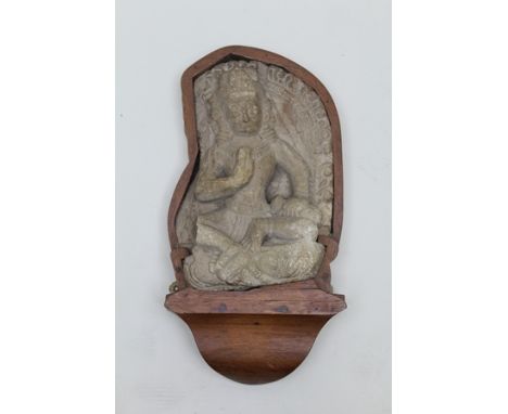 A CARVED LIMESTONE "BODHISATTVA" considered to be 18th century Hindu Indian Deity in a meditative pose, right hand raised, wi