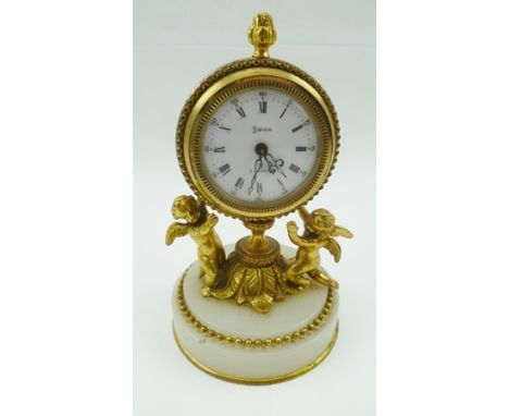 A "HALCYON DAYS" DECORATIVE FRENCH STYLE BOUDOIR CLOCK, having cast gilt brass frame as two putti supporting the timepiece, t