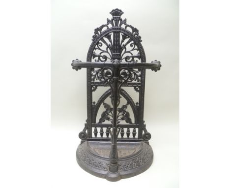 A VICTORIAN CAST IRON STICK STAND having arched pierced back with stylised floral motifs, a bow front frame, removable drip p