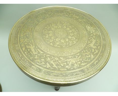 AN EARLY TO MID 20TH CENTURY EASTERN BRASS TOPPED OCCASIONAL TABLE, the top engraved with a hunting scene depicting animals a