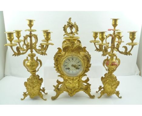 A LATE 19TH CENTURY GILT METAL FRENCH CLOCK GARNITURE GROUP, comprising the central clock, flanked by a pair of candelabra, c