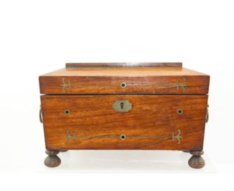 A REGENCY ROSEWOOD TEA CADDY, having brass inlaid decoration, brass ring handles, raised on turned feet, 31cm wide 