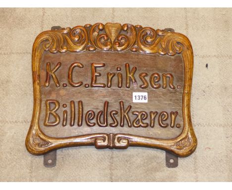 A DANISH WOOD CARVERS SIGN FRAMED IN ART NOUVEAU FLOURISHES ABOUT K C ERIKSEN BILLEDSKAERER.   H 30  x 35cms