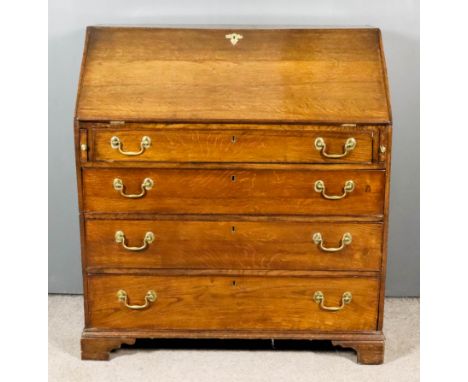 An 18th Century Oak Bureau, the slope enclosing shaped interior, fitted central cupboard, six niche and fifteen small drawers
