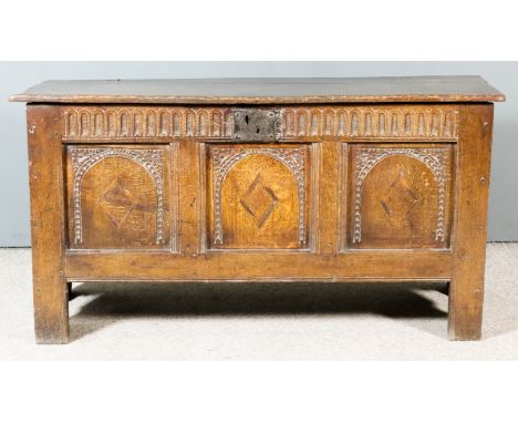 A 17th Century Oak Plank Coffer, the plain two-plank lid with moulded front edge, the three-panel front with fluted frieze an