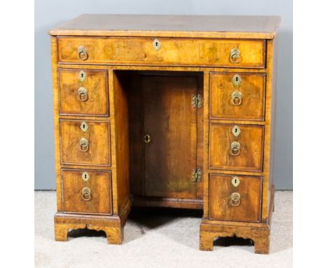 A George II Lady's Walnut Kneehole Dressing Table, the quarter veneered top inlaid with herringbone banding and crossbanded a