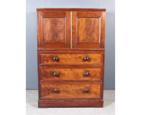 A Victorian Mahogany Cabinet on Chest, the upper part with moulded cornice enclosed by a pair of panel doors, the base fitted