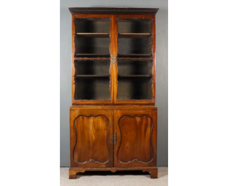 An Early George III Mahogany Bookcase, the upper part with moulded and dentil cornice, fitted three adjustable shelves, enclo