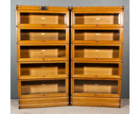 A Pair of Edwardian Globe Wernicke Oak Five-Tier Sectional Bookcases, the glazed rising fronts inset with bevelled glass pane