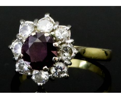 A Ruby and Diamond Ring, Modern, in 18ct gold mount, set with a central faceted ruby, approximate weight 1ct, surrounded by e