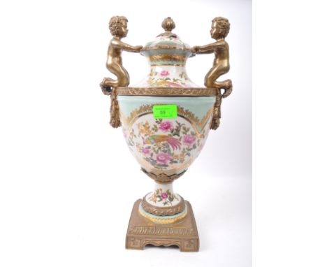 A large 19th century Victorian style ceramic and gilded metal twin handled urn vase. The vase having feather finial atop lid 