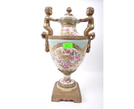 A large 19th century Victorian style ceramic and gilded metal twin handled urn vase. The vase having feather finial atop lid 