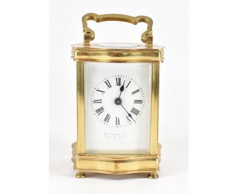 A 20th Century brass cased carriage clock. The clock having a brass body with serpentine formed top and base, with glass pane