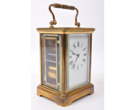 An early 20th century brass carriage clock with white enamelled face and roman numerals to chapter ring, The clock having swa