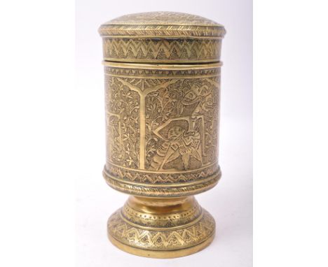 A 20th century Indian brass tea caddy having intricate engravings featuring vignettes with icons to panels in the body raised