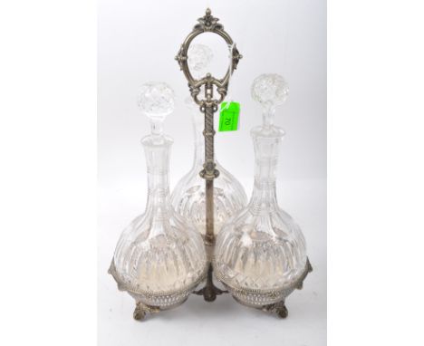 A Victorian 19th century silver plated three galleried basket tantalus with three decanters of bulbous shape &amp; stoppers. 