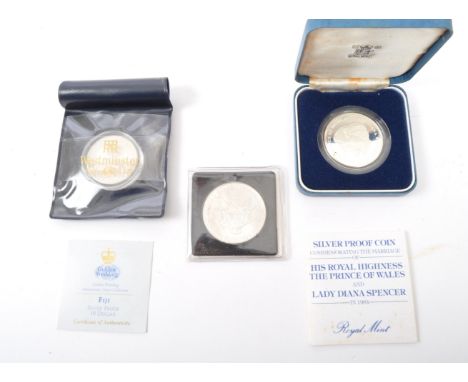 An assortment of three vintage 20th century UK &amp; US silver commemorative coins. The lot to include a United States of Ame