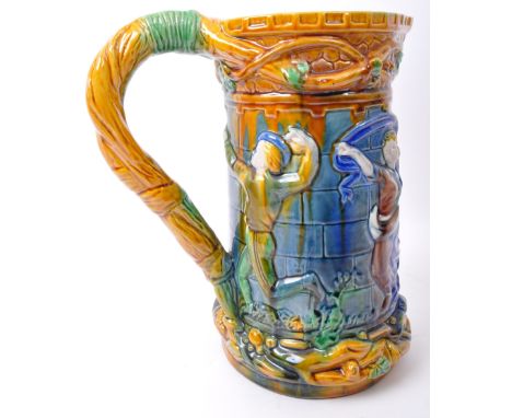 A contemporary majolica style ceramic pottery jug in bright green, blue &amp; yellow colourways depicting medieval characters