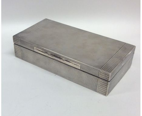 An Art Deco engine turned silver cigarette box with hinged top. Approx. 445 grams. Est. £100 - £150.