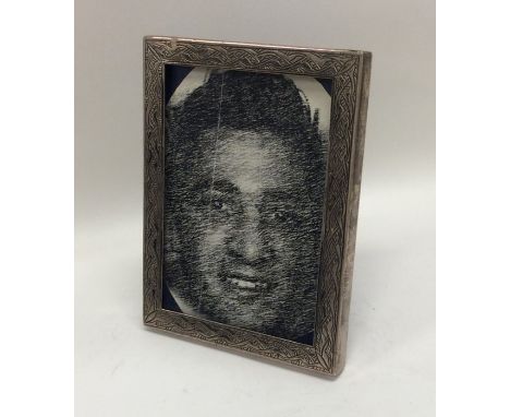 An engine turned rectangular silver picture frame. Approx. 14 cms x 11 cms. Approx. 208 grams. Est. £50 - £80.