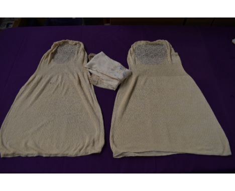 A pair of cream Edwardian stockings and two sleeveless modesty panel vests.