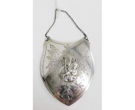 White metal decanter label of shield form with eagle engraved pattern and Madonna and child to centre, 9cm long  