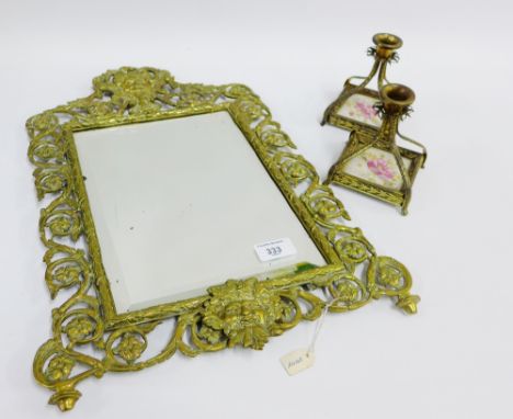 Victorian brass framed mirror with bevelled edge plate together with a pair of brass candlesticks, (3) 