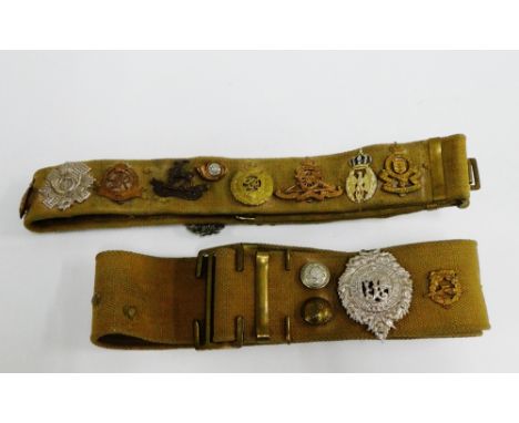 Two military canvas belts containing a quantity of various Army badges to include The Scottish Kings Own Borderers, Royal War