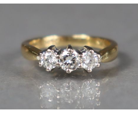 An 18ct gold ring set three graduated round-cut diamonds, the centre stone approx. 0.2 carat; size: J/K, 4gm.