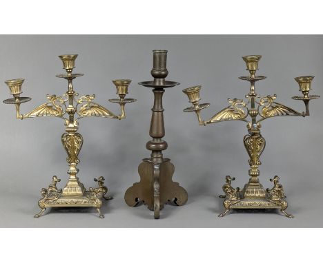 A brass tall candlestick with wide drip-pan, round tapered column, &amp; on triform scroll base, 35cm; &amp; a pair of Victor