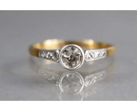 A diamond ring, the round-cut stone approx. 0.25 carat, trios of rose diamonds to the shoulders, the shank marked: “18ct. &am