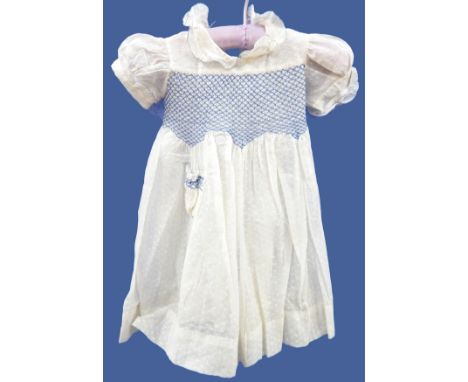 Various 1940's or earlier child's dresses including a cream figured muslin with blue smocking detail and puff sleeves, a cott