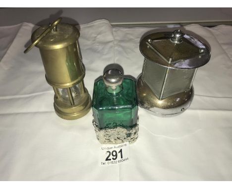 A vintage Pifco night light, a brass miner's lamp and a green glass and silver plate scent bottle.