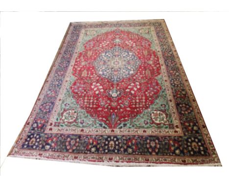 A modern Iranian Kashan wool/cotton carpet, with a central blue foliate medallion on a red trailing ground, 363 cm x 250cm 