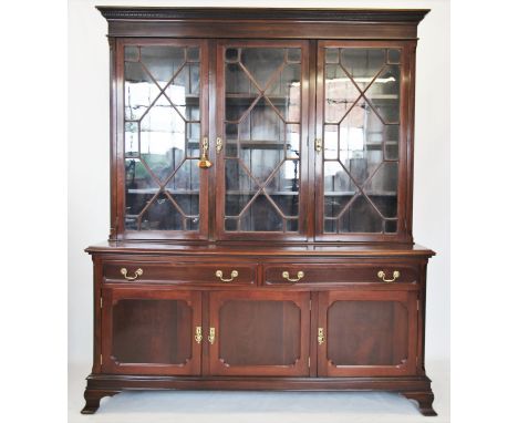 An Edwardian mahogany library bookcase, the moulded cornice with a Greek key pattern frieze above three astragal glazed doors