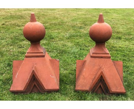 A pair of terracotta coloured, gate capitals/finials, each of architectural form, tapering square with ball finial, 75cm H x 